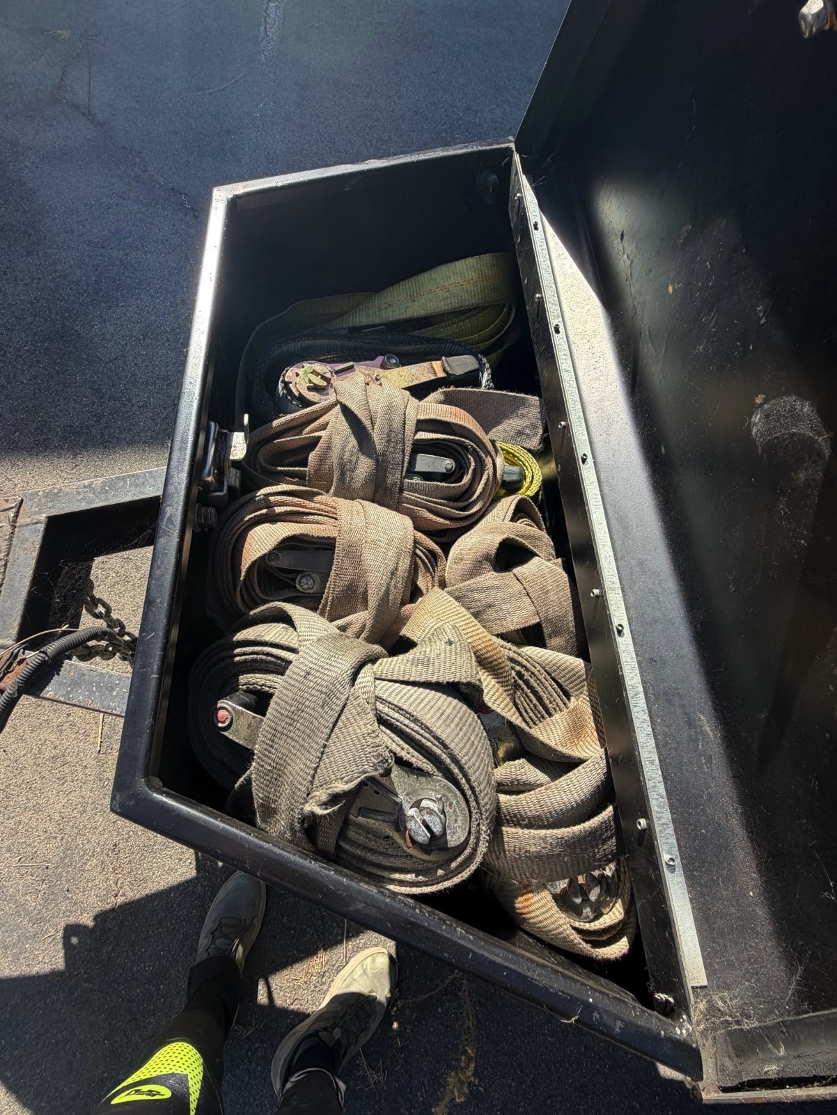 Tie-down straps stored inside the metal tongue box